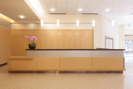 Reception desk and wall accents in ViviChrome Chromis glass with Taupe interlayer and Opalex finish at Lloyd Center Tower, Portland, Oregon