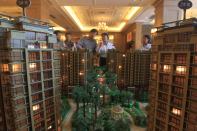 Chinese homebuyers look at models of apartment buildings during a real estate fair in Haikou City in China's Hainan province on Nov. 29. According to a recent survey, China's housing prices fell on a monthly basis for the seventh straight month in November, with the market yet to feel the full impact of an interest rate cut. The average price of a new home in China's 100 major cities was 10,589 yuan ($1,736) per square metre in November, down 0.38 percent from October, according to the China Index Academy.