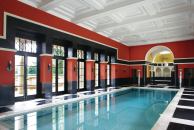 The marble floors continue into the pool hall, which is lined with Pompeian red walls. The hot tub in the apse is flanked by a sauna and a steam room.