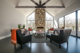 Modern Barn® Room with 12'x9' sliders on the right that lead out deck, gas fireplace with New England custom cut stone, 24' cathedral ceiling