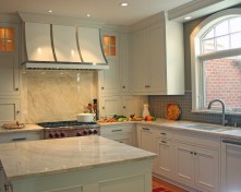 After shaking up the plan by moving walls, eliminating doors and enlarging the window, the new space was furnished with finely tailored cabinetry, quartzite tops and a custom built range hood as the focal point.
