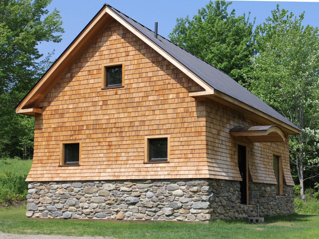 Figure 1. Approximately two years ago, my wife and I broke ground on a super-insulated home based on Passive House design, in Morrisville, Vt. We built the 1,000-square-foot home on property we owned with the notion of moving into it when we downsize our lives in the future (in the near term we plan to rent it out). And although we built it to meet PHIUS Passive House certification—adding saleable value—we’re not pursuing official PHIUS certification. Our goal was to build an attractive home that needs very little energy to heat in the winter and cool in the summer. With the help of Passive House consultant, Chris West of Eco Houses of Vermont, we built a cozy, aesthetically-pleasing home with the lowest heating bills modern building science can provide. The whole house has a heating load of approximately 3,200 Btu/hour at -2°F. The typical code-built house of this size has a heating load in the 50,000 Btu/hour range. For information about the detailing of home’s stone and cedar shingle cladding, see Backfill (Jun/16).