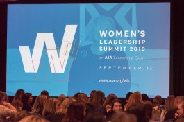 Liz Warren (in background), faculty director at the South Mountain Community College Storytelling Institute, coached the storytellers who took to the Women's Leadership Summit main stage.