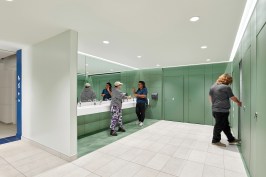 Finished in a palette of calming shades, durable tile flooring, and fixtures from American Standard, Elkay, Bobrick, and Koala Kare, each restroom comprises 11 individual stalls.