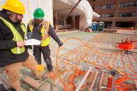 Snowmelt installers review the circulation layout for hydronic tubing as they complete their work prior to a concrete pour at York Hospital in Pennsylvania. Photo courtesy Watts.
