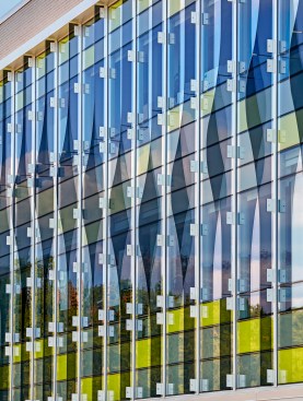 Oscillating vertical glass fins cast shadows across the building creating a dramatic effect throughout the day.