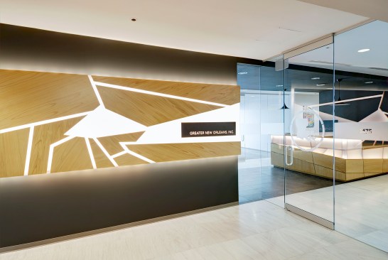 Entry with custom feature wall and reception desk designed and built by NANO LLC from 3form Chroma and cypress plywood.