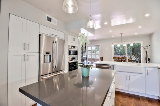 White shaker cabinet, Open space kitchen with quartz counter top. 
Wood flooring 