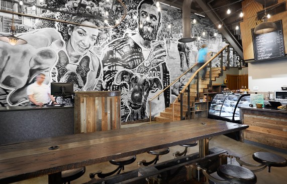 The industrial aesthetic is complimented by the Benson Brother’s mural, which fills the interior wall on the street level and continues up the stairs to the skywalk level. 