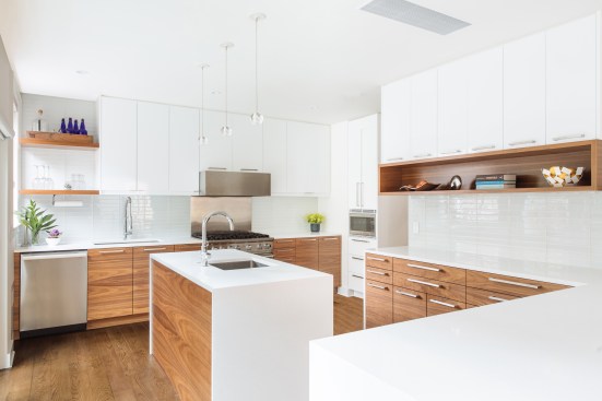 Walnut base cabinets with sequenced figured grain is paired with white upper cabinets; floating shelves and displays in walnut provide accents.