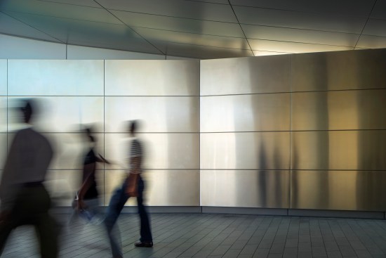 The entryway portal's angled stainless steel walls and aluminum ceiling reflect the colors of the sky, earth, and water.