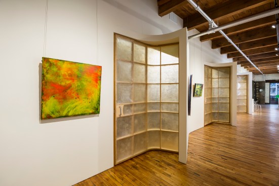 Unique translucent swiveling doors along wall in gallery that allow for better display of artwork