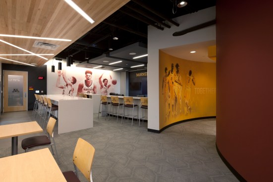 The men’s basketball player’s lounge comes to life with full-wall graphics of current players in
splashes of maroon and gold.