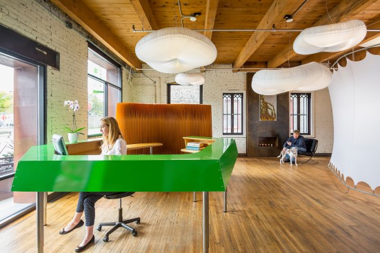 Woman sitting at front desk of chiropractor's office with custom metal desk