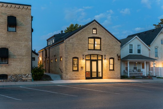 Front facade of old livery buidling seen from angle at dusk