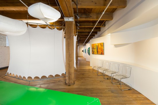 An art gallery and event space that is owned by a chiropractor with treatment rooms that are made of stretched cloth pods that can be raised and lowered as needed