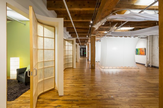 Chiropractor's flexible work space with several doors that lead to offices and treatment pods that can be raised and lowered