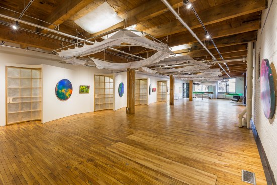 Event and gallery space that can be converted to a working chiropractor's office by lowering cloth pods - pods are raised in this photo