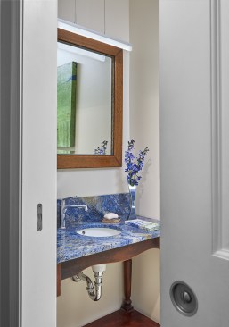 Photo shows the entrance to the powder room with sliding pocket door