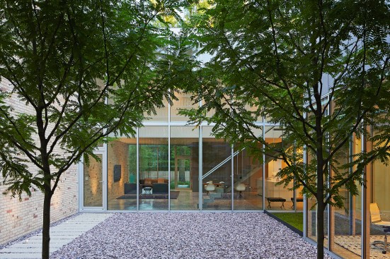 In the entry courtyard, perimeter walls of Chicago common brick give way to a transparent living volume clad in Solarban 80 glazing from Vitro.
