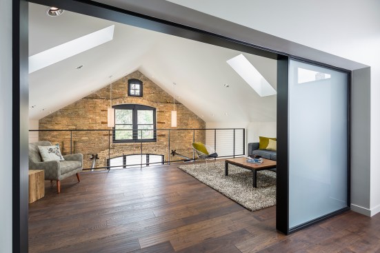 Loft of newly renovated old buildng with view down to original brick wall