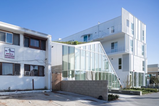 The pavilion is clad in an Acadia storefront system, while the units above feature vinyl windows from VPI Quality Windows.