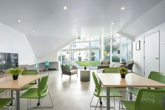A community room which opens out onto the communal plaza has DMF Lighting downlights in a ceiling coated in Dunn Edwards paint.