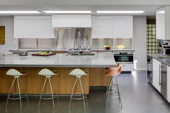 The new modern kitchen caters to avid cookers (our clients) and makes a statement with a concrete kitchen island and stainless steel backsplash. The kitchen is filled with light and has a space for any activity. 