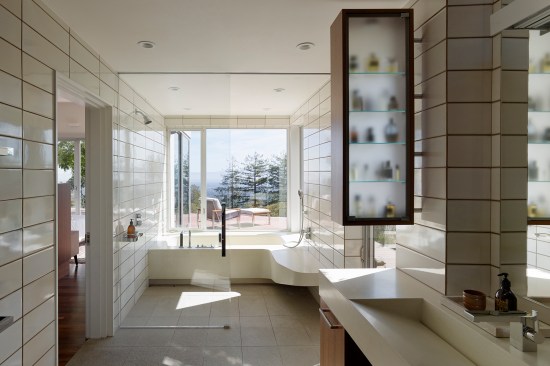 The master bath was reworked to improve the space’s ergonomics and accessibility. It overlooks one of many decks surrounding the house.