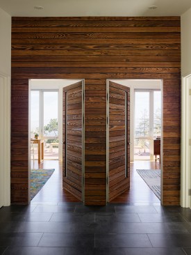 A pair of wood-clad doors lead from the main hallway in the eastern end of the house to two enlarged family bedrooms.