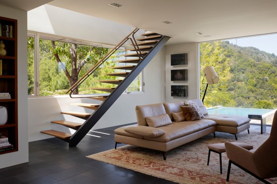 The new family room features a sculptural stair that leads to the second-floor guest suite and expansive glazing that opens the house to dramatic views of the mountaintop site.