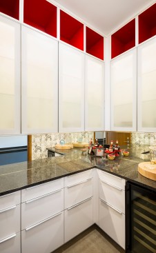Modern pantry with white Ikea cabinets with red accents
