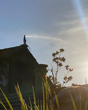 Roof-mounted automated exterior sprinkler system