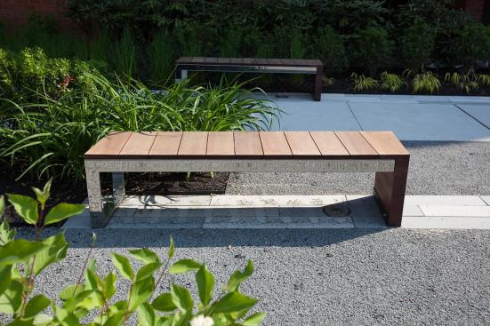 Duo Bench shown with Polished Stainless Steel frame and FSC 100% Jatoba hardwood slats and end at 80 Williams Street, Wellesley, Massachusetts