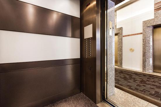 LEVELe-104 Elevator Interior with main panels in ViviChrome Chromis glass, White interlayer, Opalex finish; upper accent and handrail panels in Fused Nickel Silver, Sandstone finish; lower accent panels in Fused Nickel Silver, Sandstone finish, Dallas Impression pattern at 1000 Broadway, Portland, Oregon