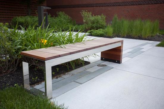 Duo Bench shown with Polished Stainless Steel frame and FSC 100% Jatoba hardwood slats and end at 80 Williams Street, Wellesley, Massachusetts