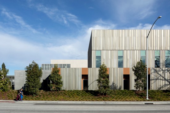 The material palette of variegated aluminum panels, terra cotta-colored cement board, and board-formed concrete responds to the park-like setting of the existing campus.
