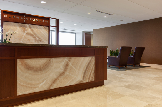 Reception desk and partition in ViviStone Cream Onyx glass with Pearlex finish at Burr & Forman, Orlando, Florida