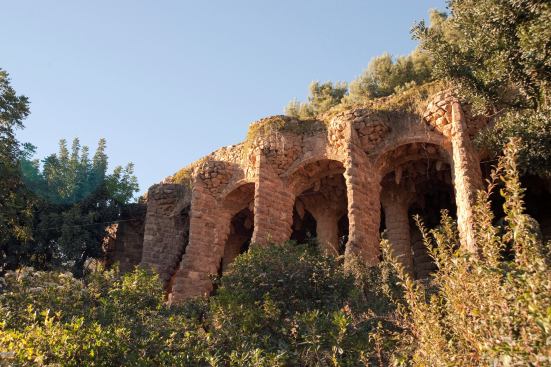 The colonnade, which supports a viaduct over a footpath, features stone masonry columns angled to resist structural loads in compression only.