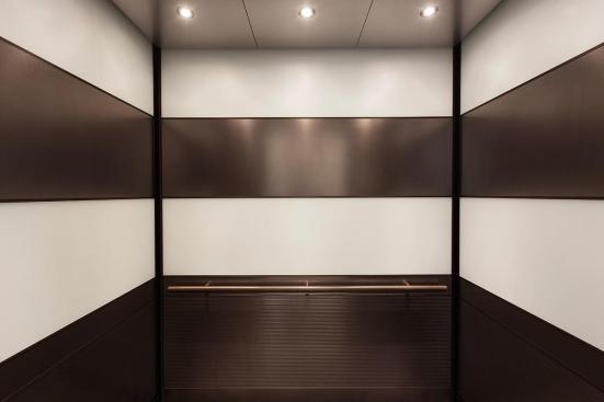 LEVELe-104 Elevator Interior with main panels in ViviChrome Chromis glass, White interlayer, Opalex finish; upper accent and handrail panels in Fused Nickel Silver, Sandstone finish; lower accent panels in Fused Nickel Silver, Sandstone finish, Dallas Impression pattern at 1000 Broadway, Portland, Oregon