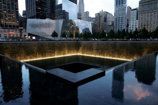 A view of the North Tower Reflecting Pool with the National September 11 Museum in the background.
