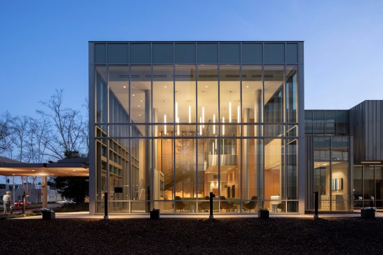 The entry lobby is visually prominent and welcoming: a two-story glass volume easily recognizable amongst the mature heritage trees on site.
