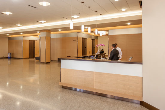Reception desk, wall accents and elevator transoms in ViviChrome Chromis glass with Taupe interlayer and Opalex finish at Lloyd Center Tower, Portland, Oregon