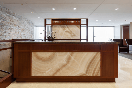 Reception desk and partition in ViviStone Cream Onyx glass with Pearlex finish at Burr & Forman, Orlando, Florida