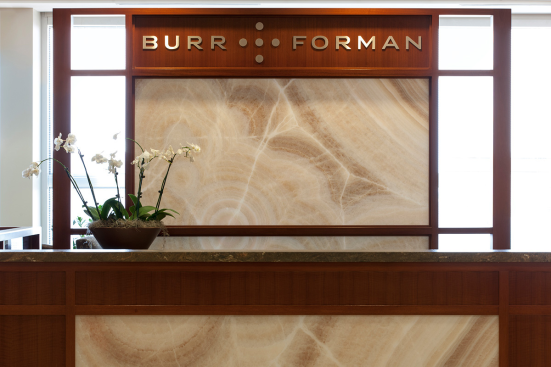 Reception desk and partition in ViviStone Cream Onyx glass with Pearlex finish at Burr & Forman, Orlando, Florida