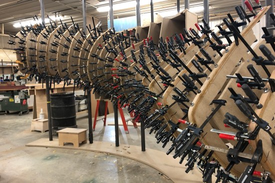 Fabricating the steam-bent oak panels required a combination of traditional craftsmanship with laser scanning and projection. The augmented reality construction process placed Trahan Architects’ scripted layouts into the real world, ensuring the accuracy of the millwork form and placement.