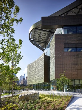 The south façade of the Bloomberg Center, showing the building's perforated metal cladding and rooftop solar canopy.