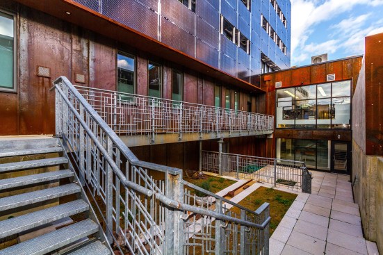 Terraced courtyard; corten steel ground floor; bifacial solar photovoltaic façade above