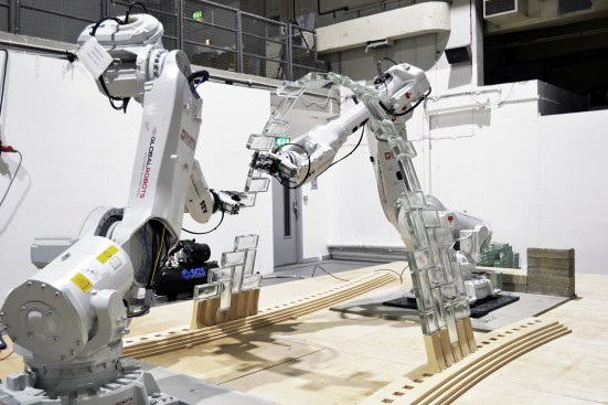 Robotic arms constructing the initial arch of the Glass Vault