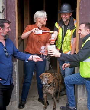 The project team share a wine pour after the successful concrete pour.